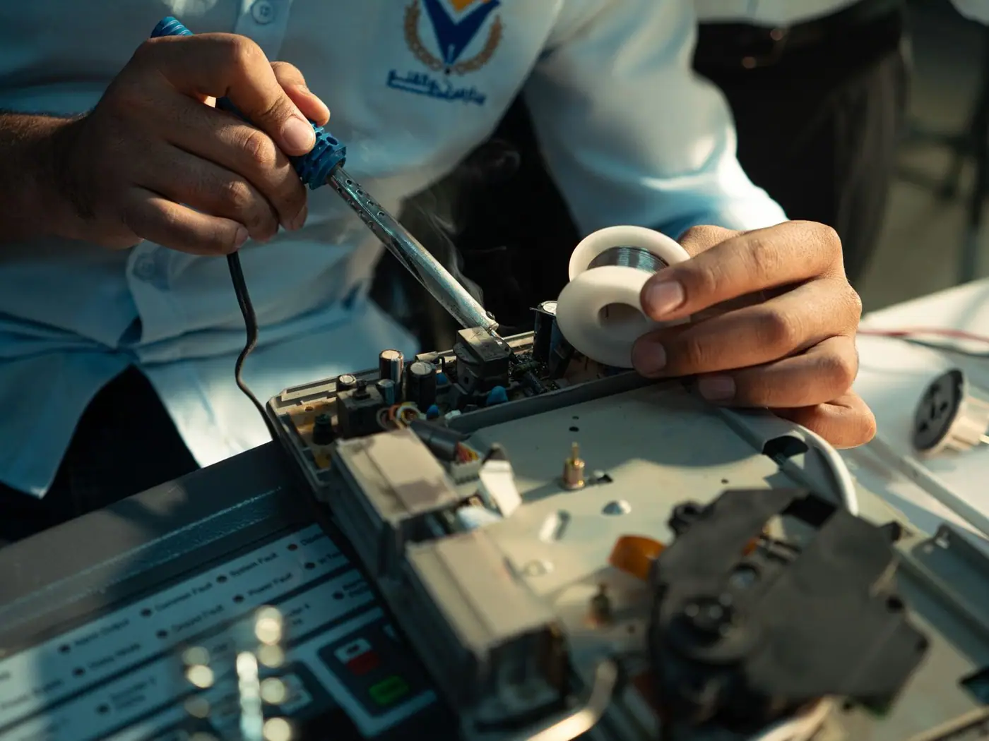 Hands soldering an electronic circuit board, close up
