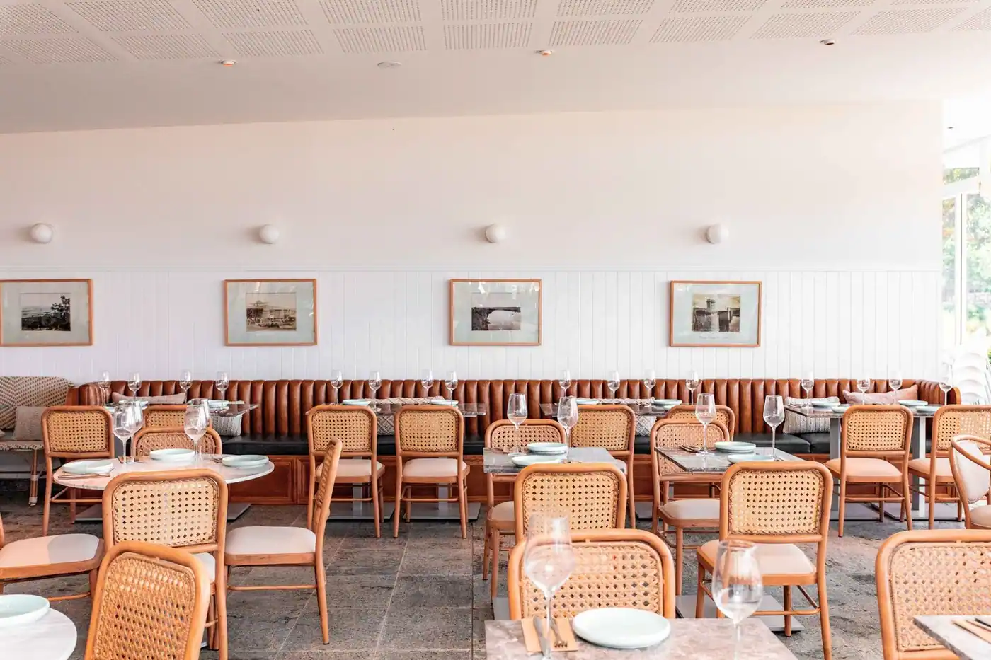 Modern restaurant interior with wooden chairs and a stylish table setting