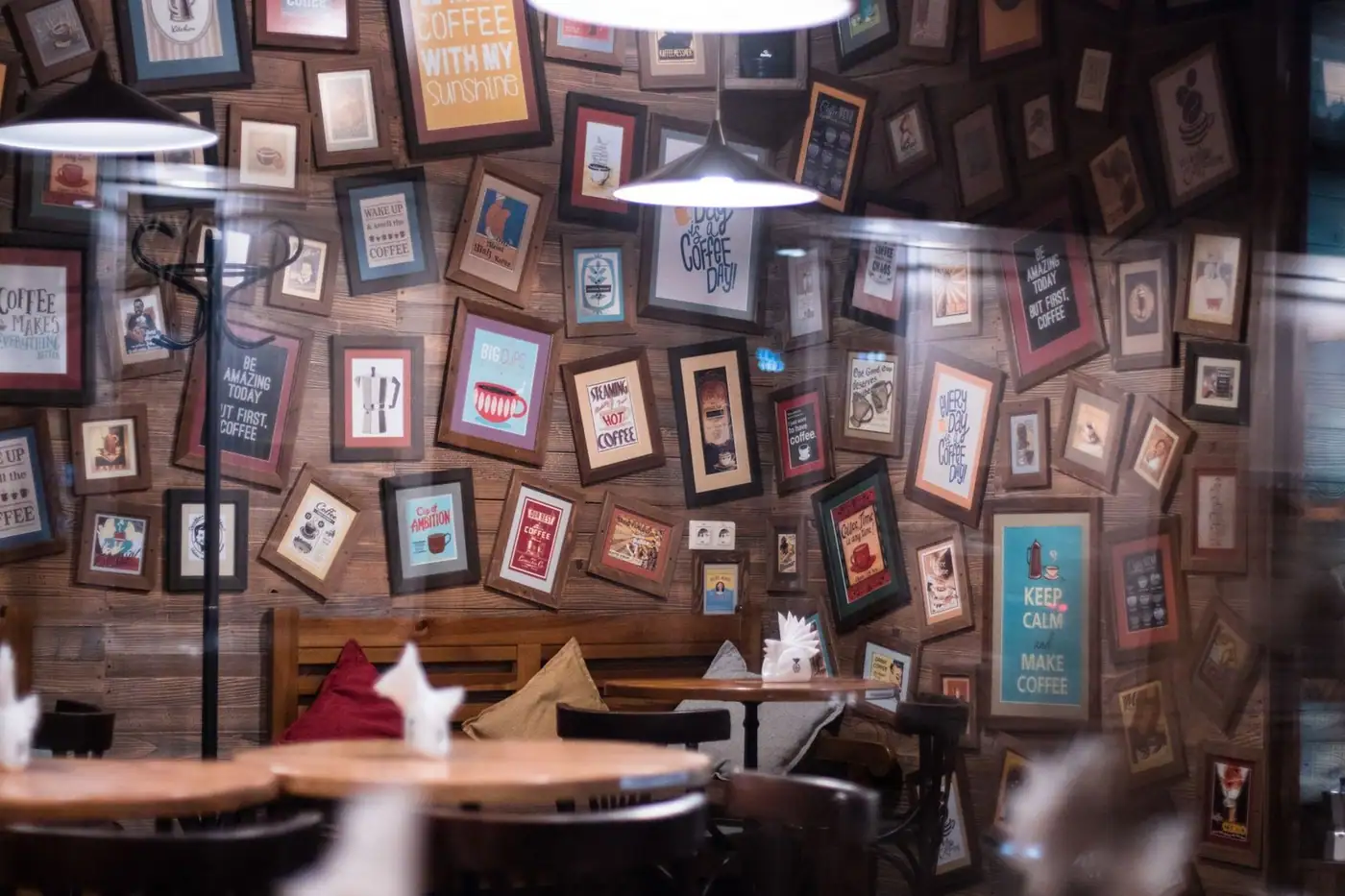 A cosy café interior with framed coffee-themed art on the wall