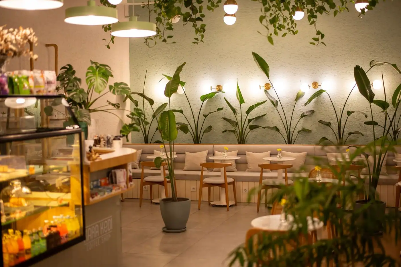 A café interior with plants and warm lighting