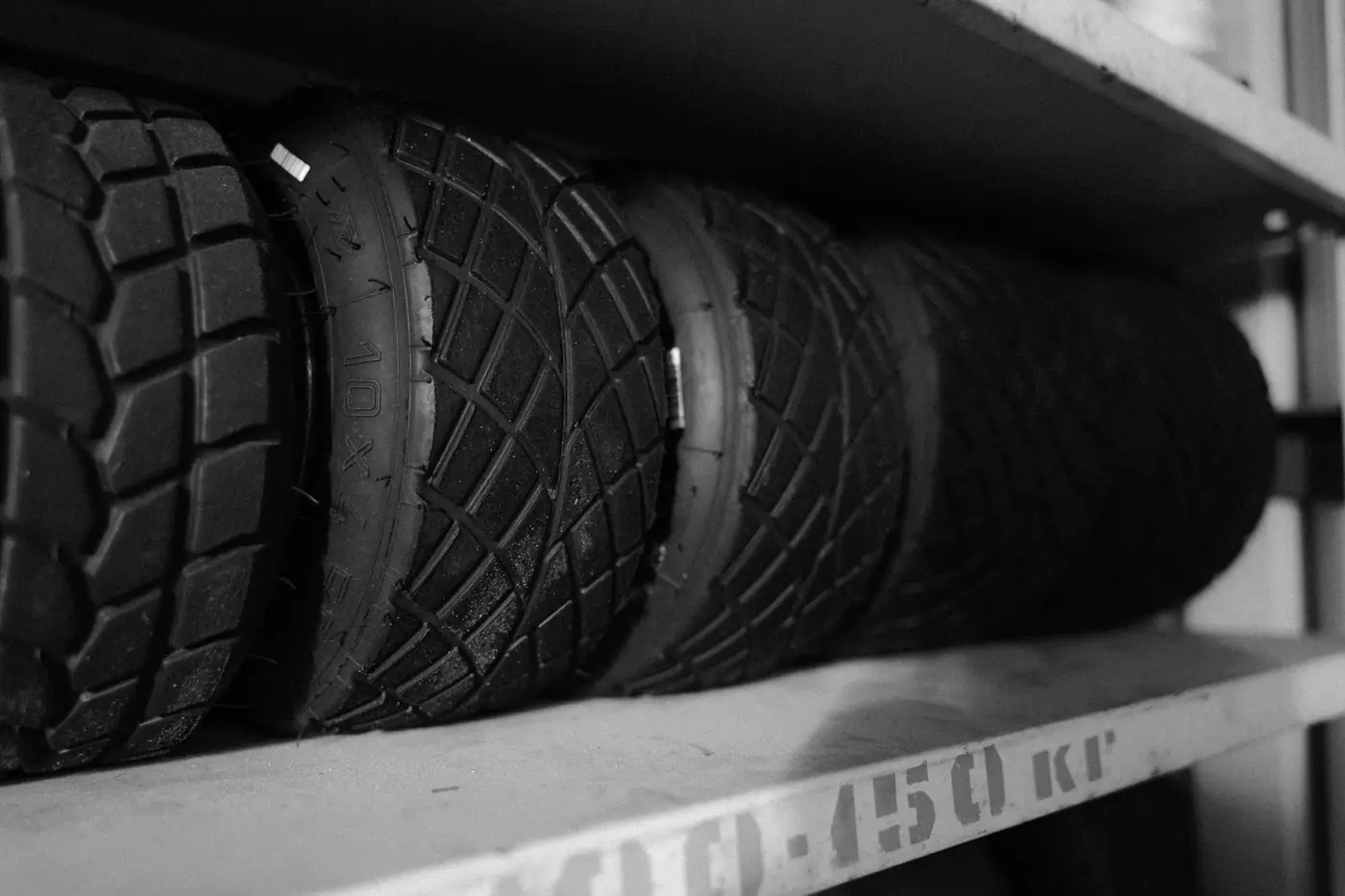 Monochrome close-up of tyres arranged neatly on a shelf