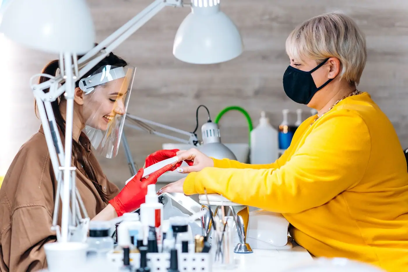 Clients receiving treatments with safety measures in place at a modern salon