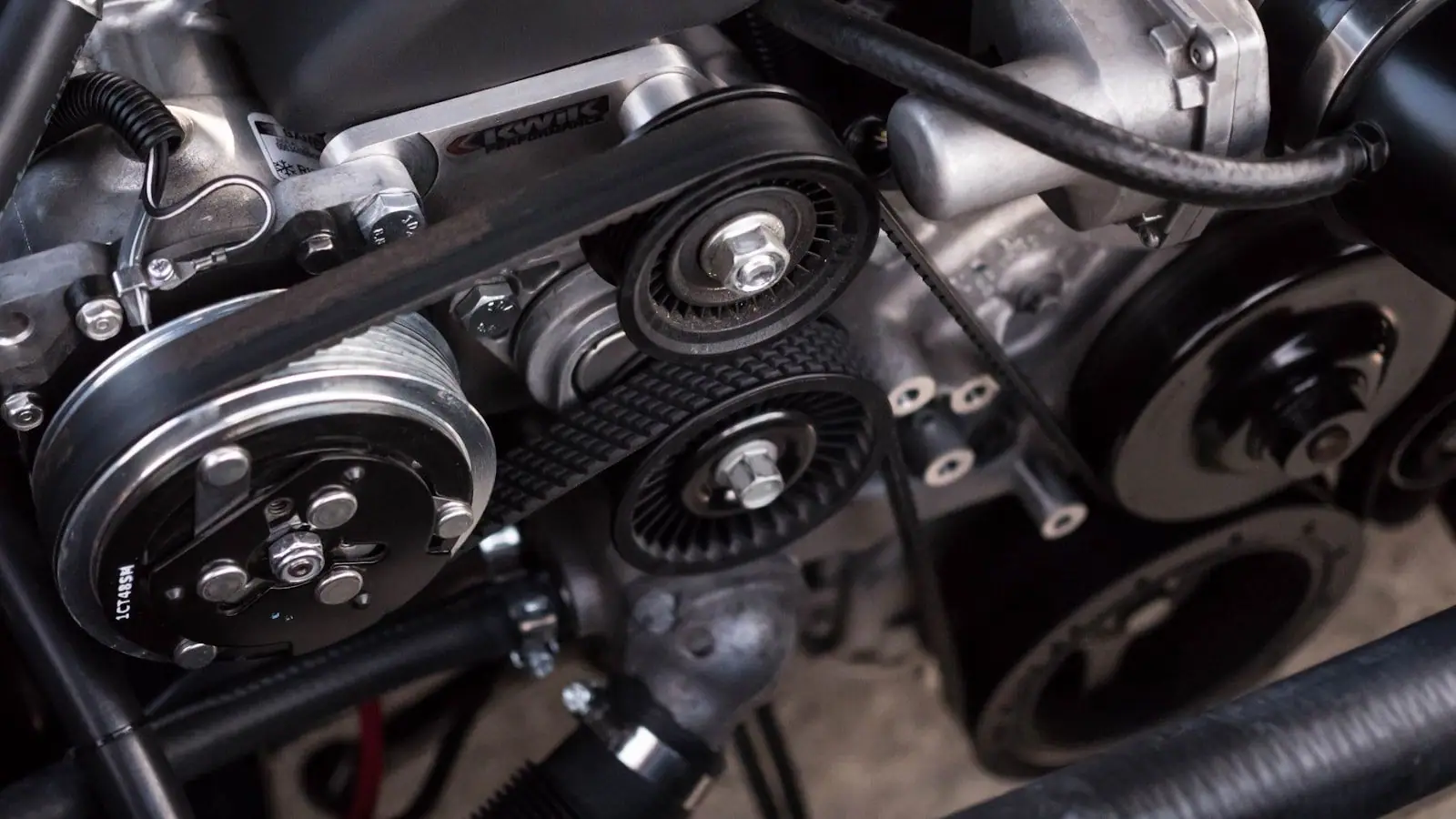 Close-up of a car engine bay showing serpentine belts