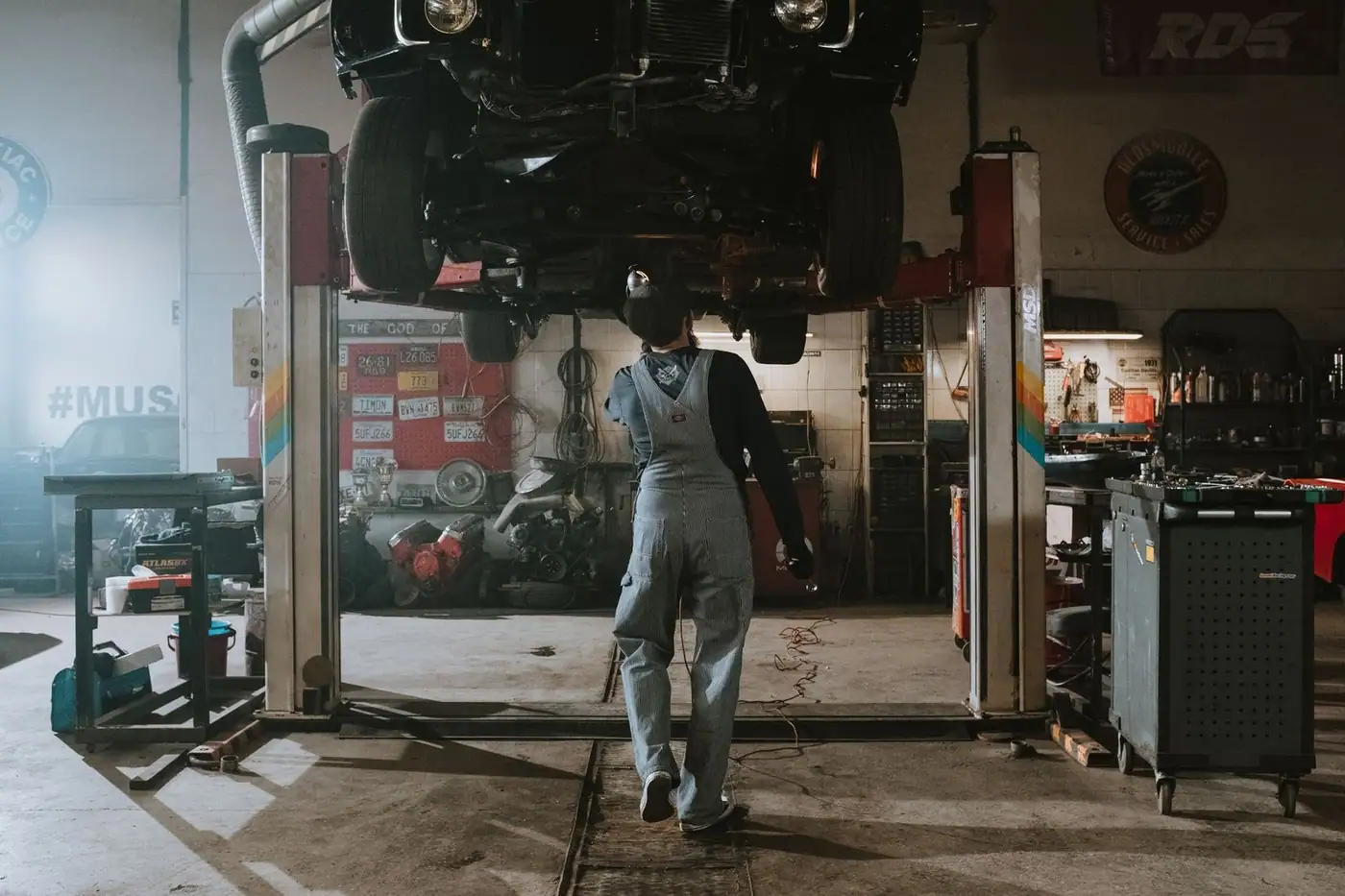 Automobile mechanic fixing a car in a repair garage, focus on service and repair work