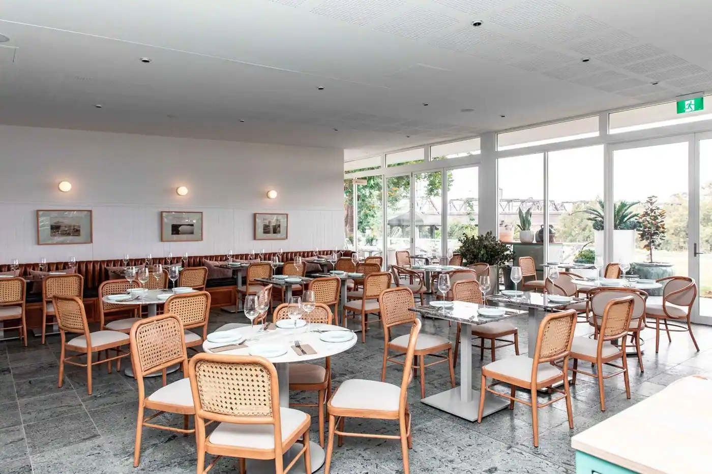 Spacious modern restaurant interior with wooden chairs and glass tables