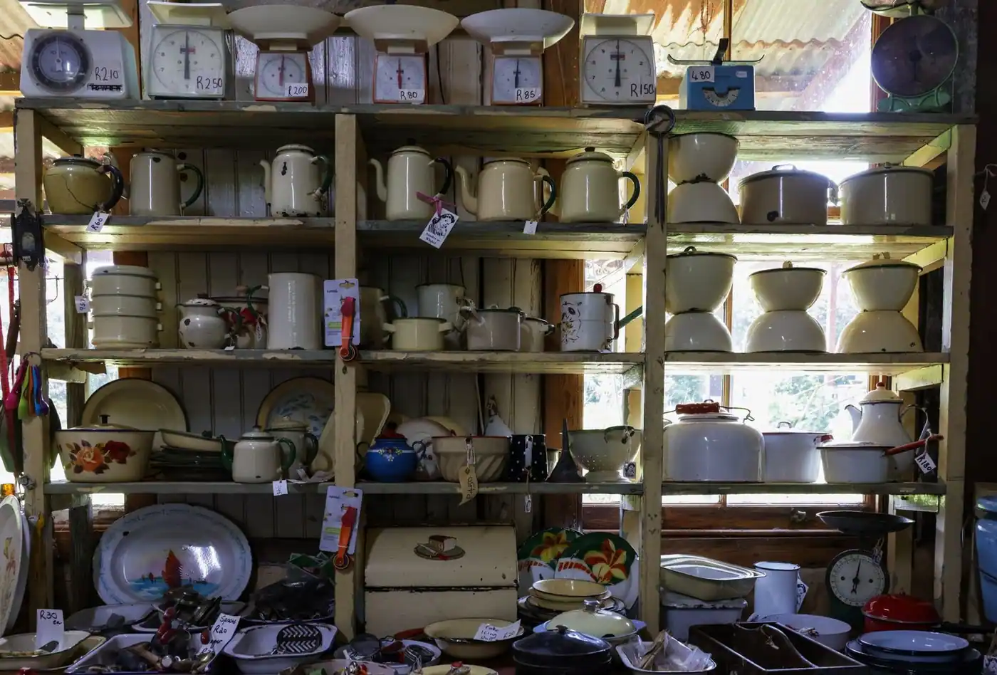 A collection of vintage kitchenware on shelves in a cosy rustic shop