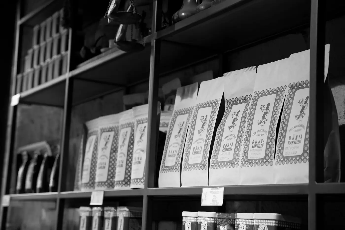 A monochrome image of goods neatly arranged on a store shelf in an organised display