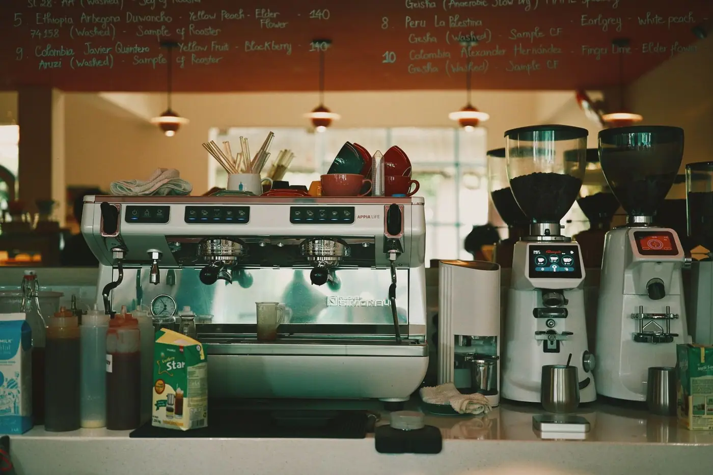 An espresso machine with cups and grinders in a cafe