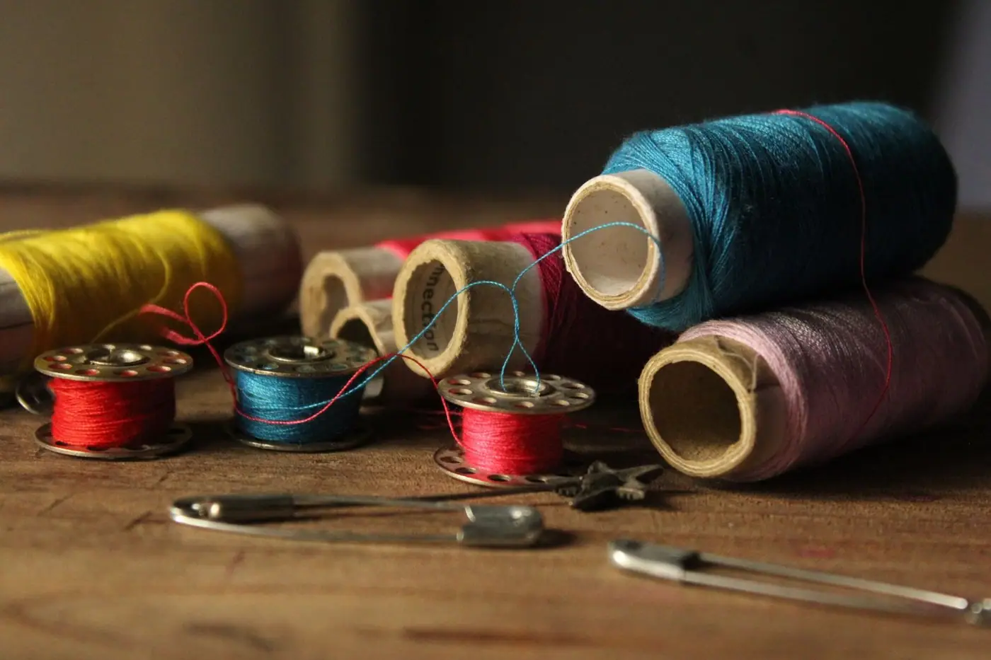 Colourful sewing threads and bobbins on a wooden table