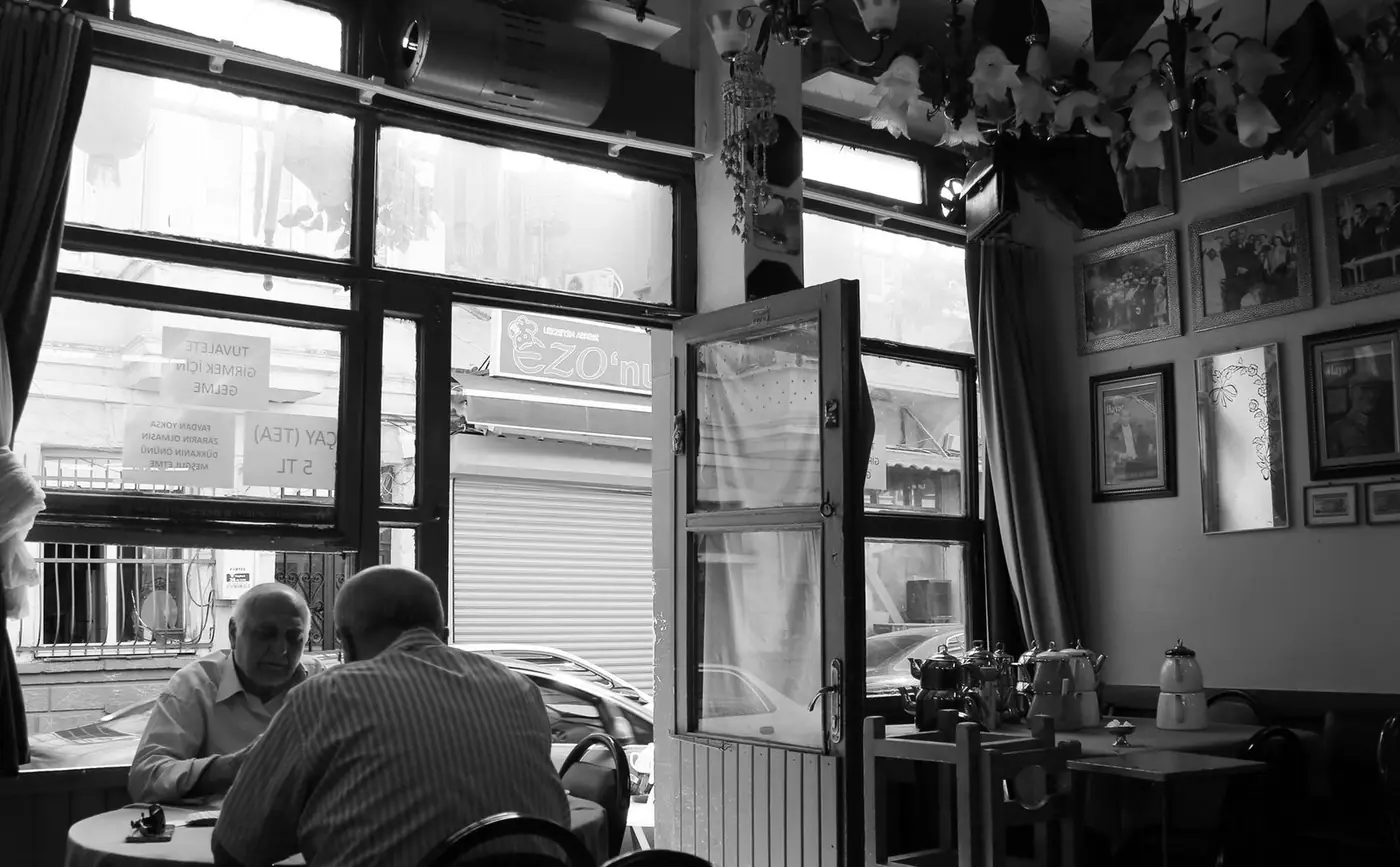 Black and white image of men dining in a cosy cafe
