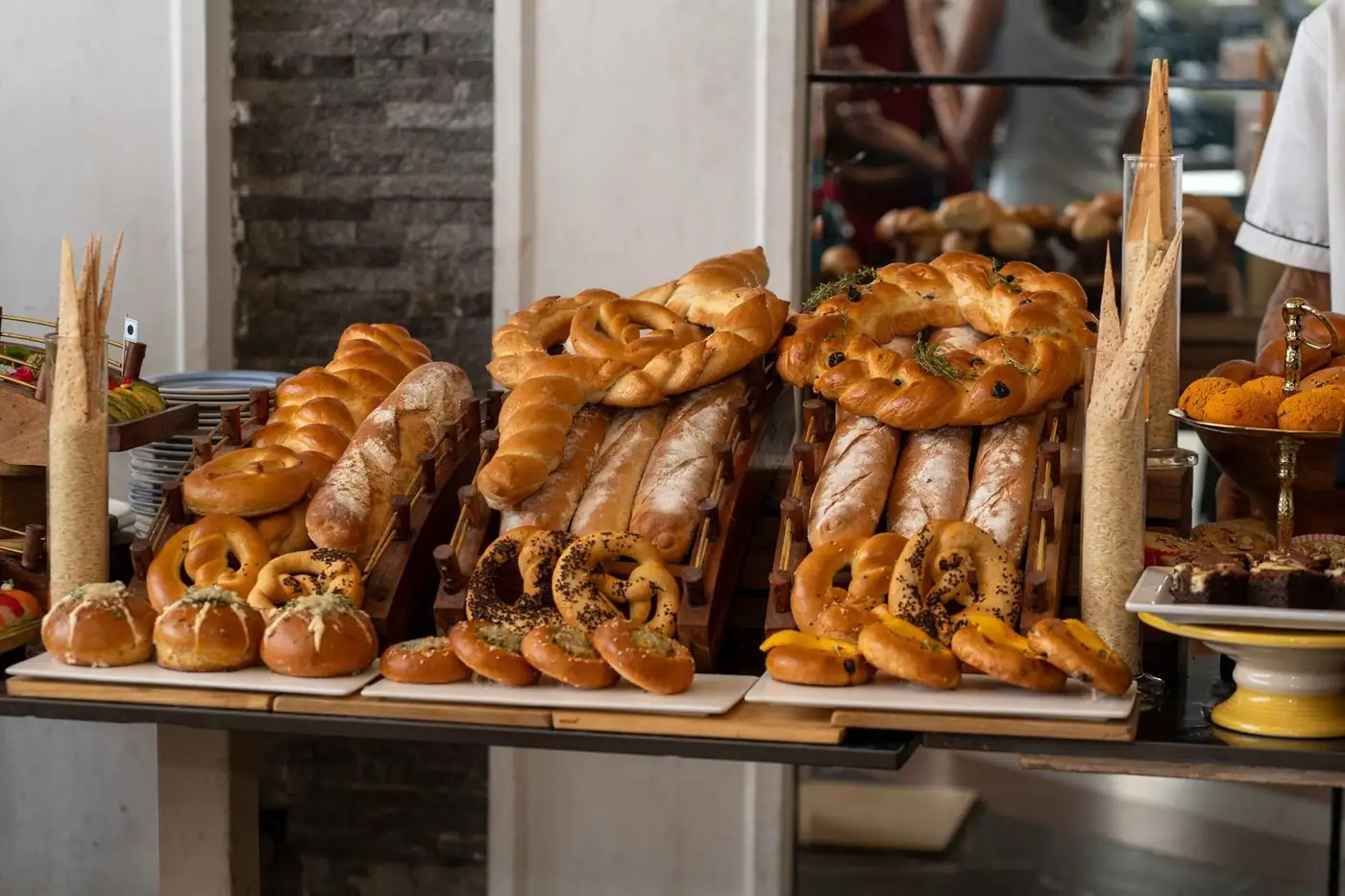 A variety of freshly baked breads and pastries elegantly displayed on a wooden table