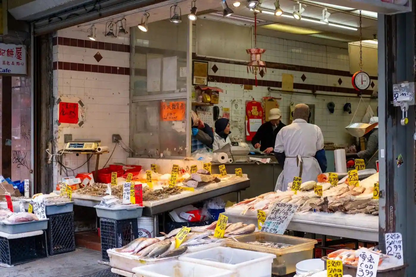 A bustling seafood market in a Chinatown, with fresh fish on display