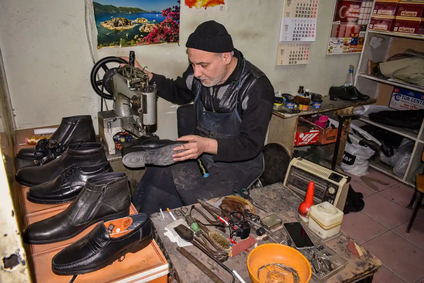 A cobbler repairing leather shoes in a traditional workshop