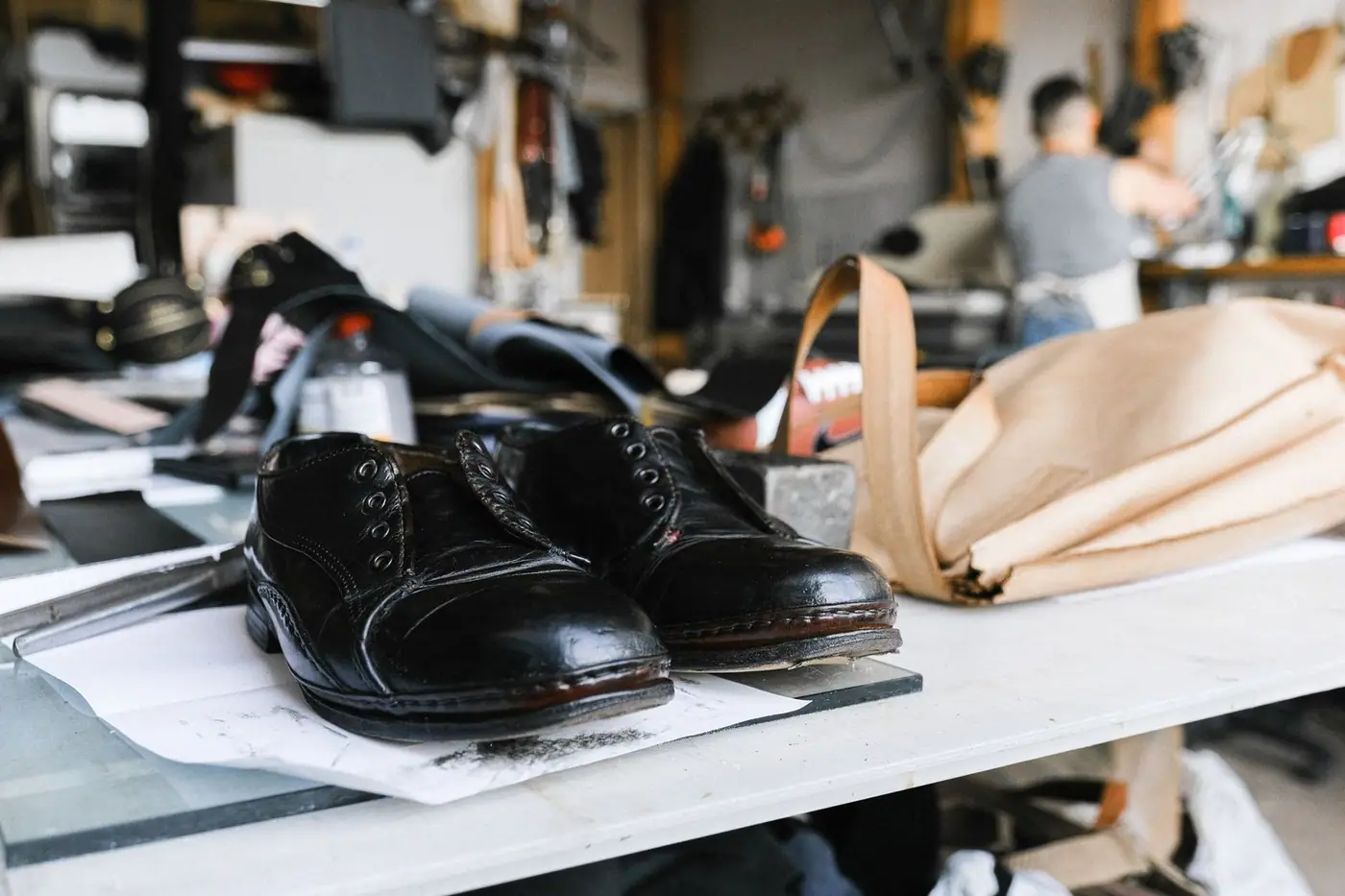 Close-up of handcrafted leather shoes resting on a craftsman's workbench