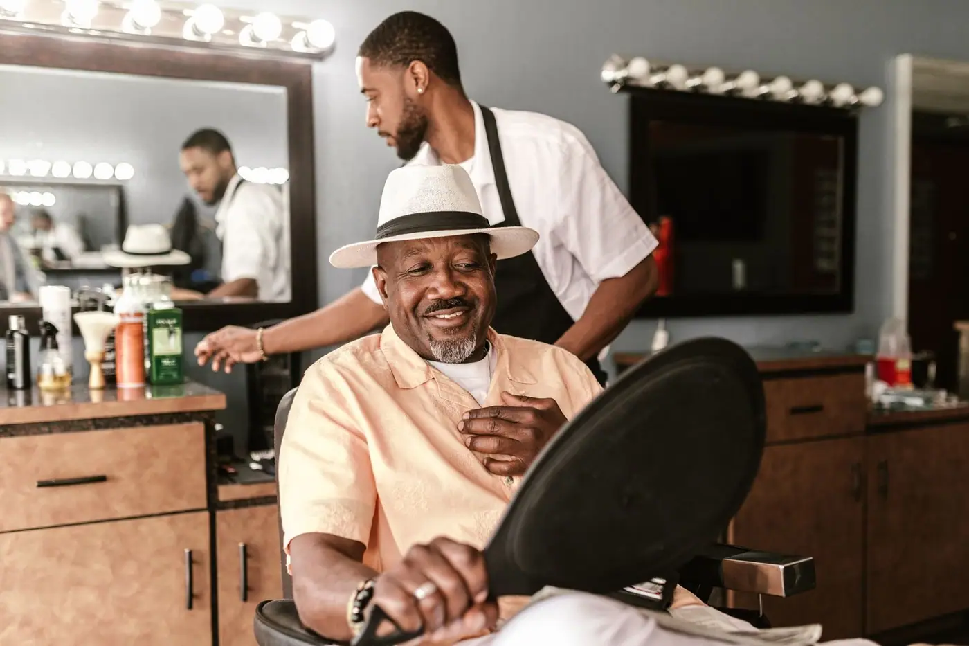 A happy customer enjoying a haircut in a stylish barber shop with a friendly barber