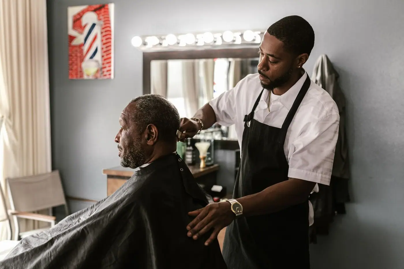 A barber carefully trimming a customer's hair in a stylish barbershop