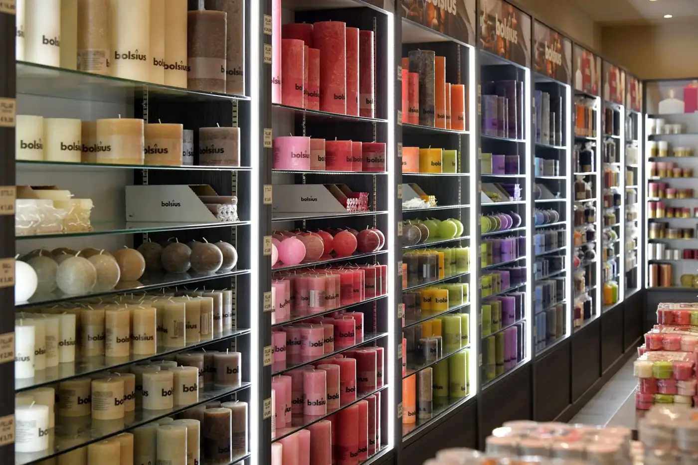An assortment of scented candles on display on a shelf