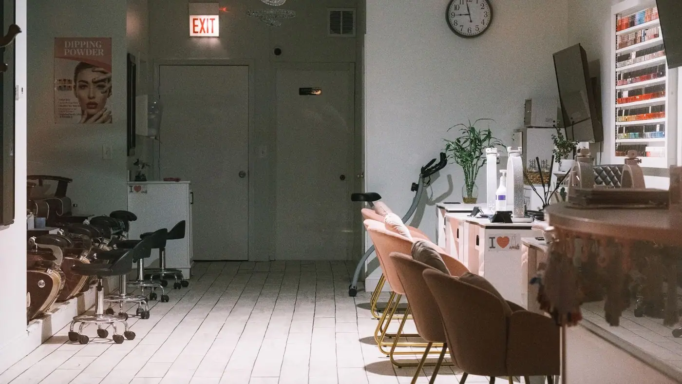 A cosy, modern nail salon interior with stylish chairs and a nail polish display
