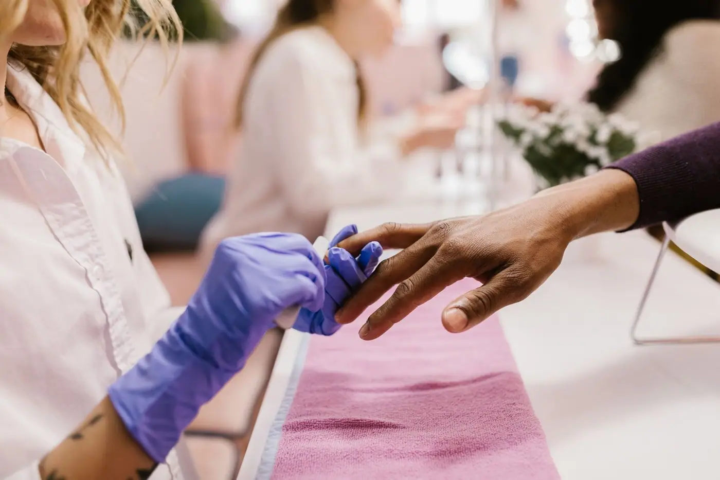 Close-up of a manicurist applying polish in a nail salon