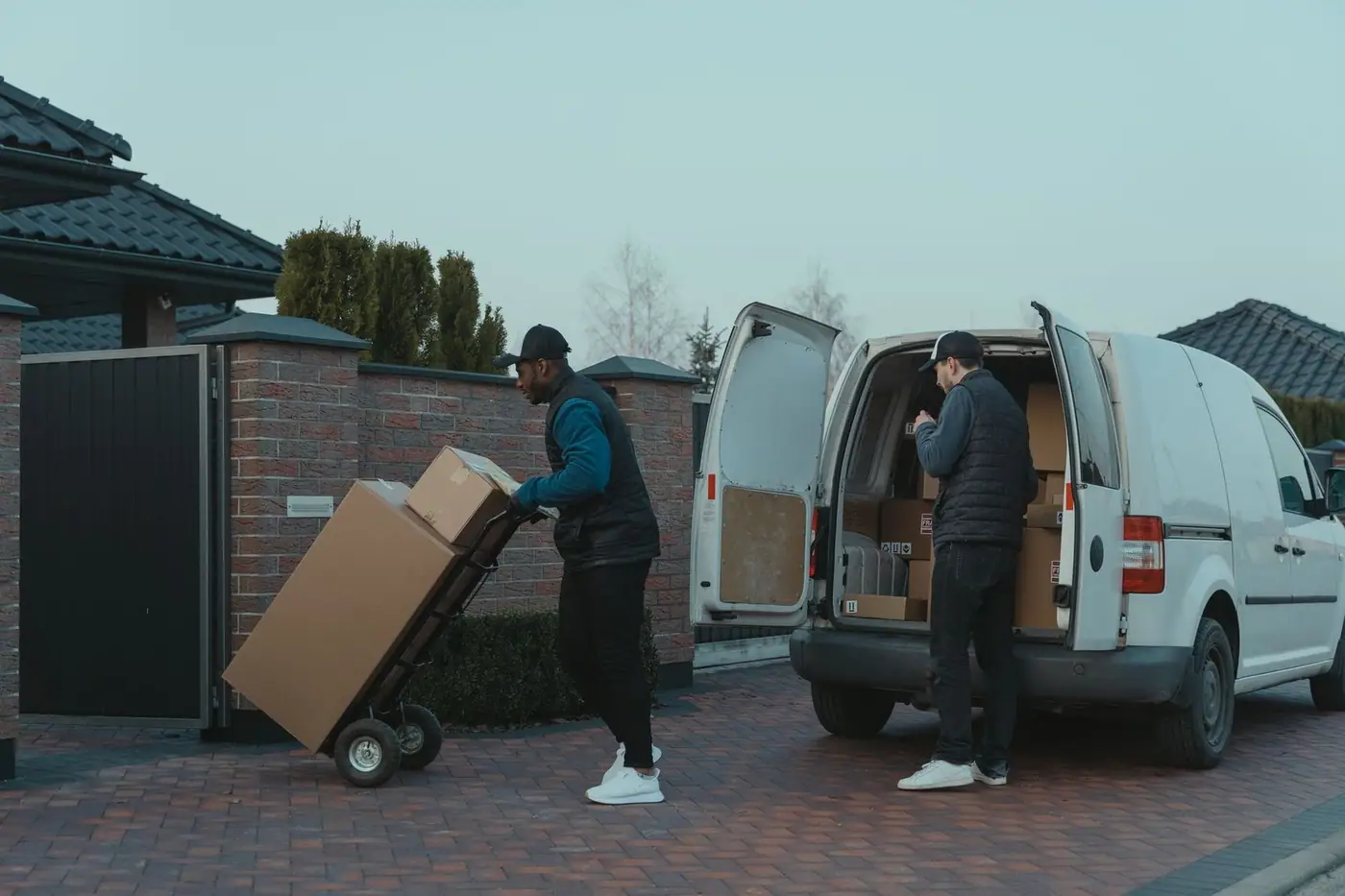 Two delivery men working from a van, unloading together