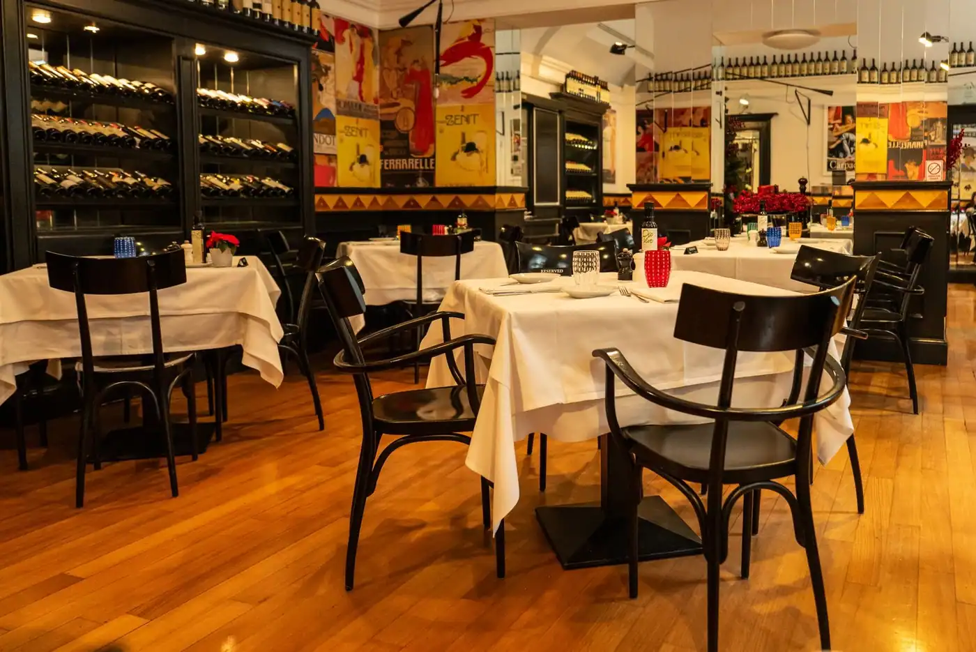 Dining space with neatly set tables and a wine display