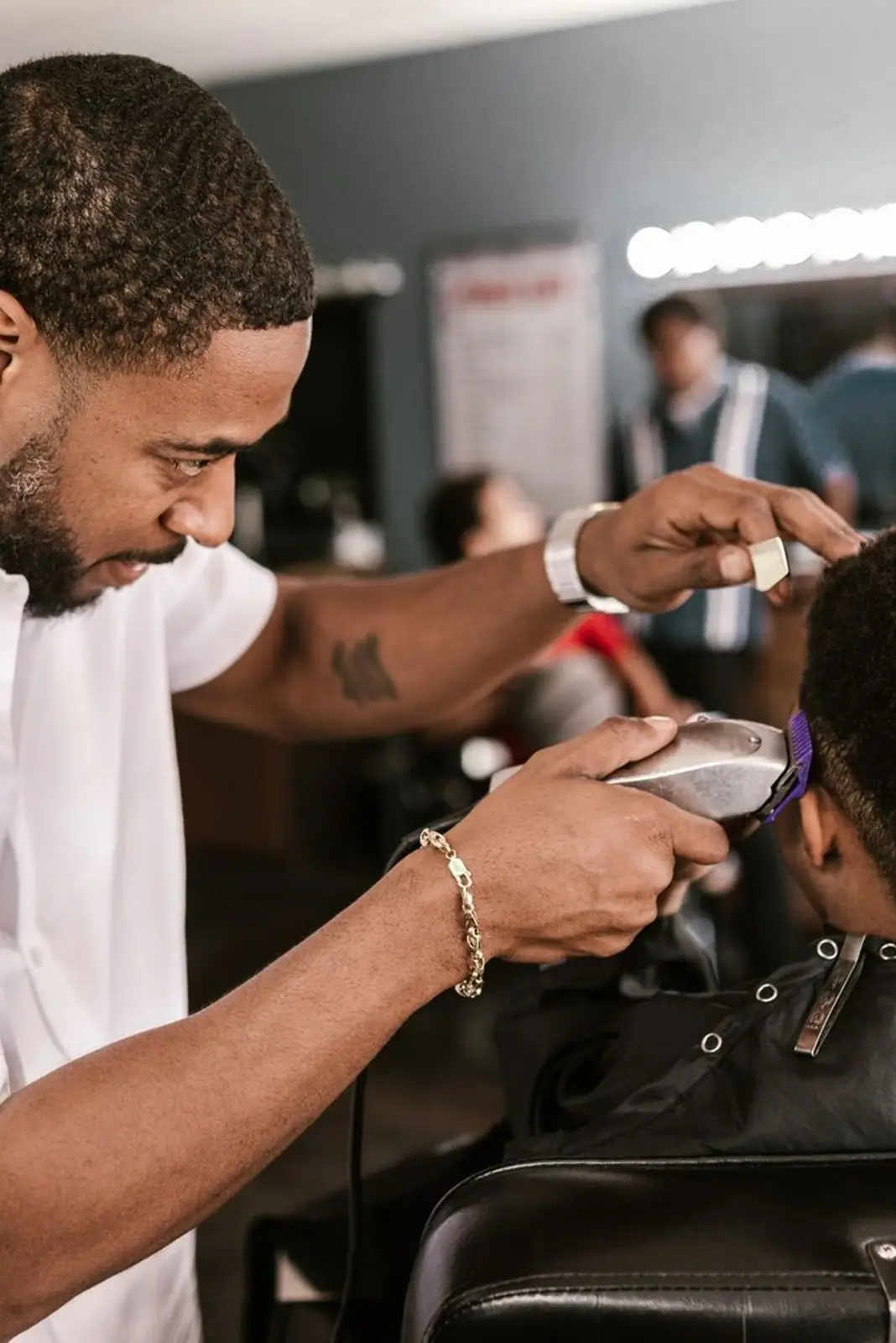 Professional barber giving a precise haircut to a client in a stylish barbershop setting.