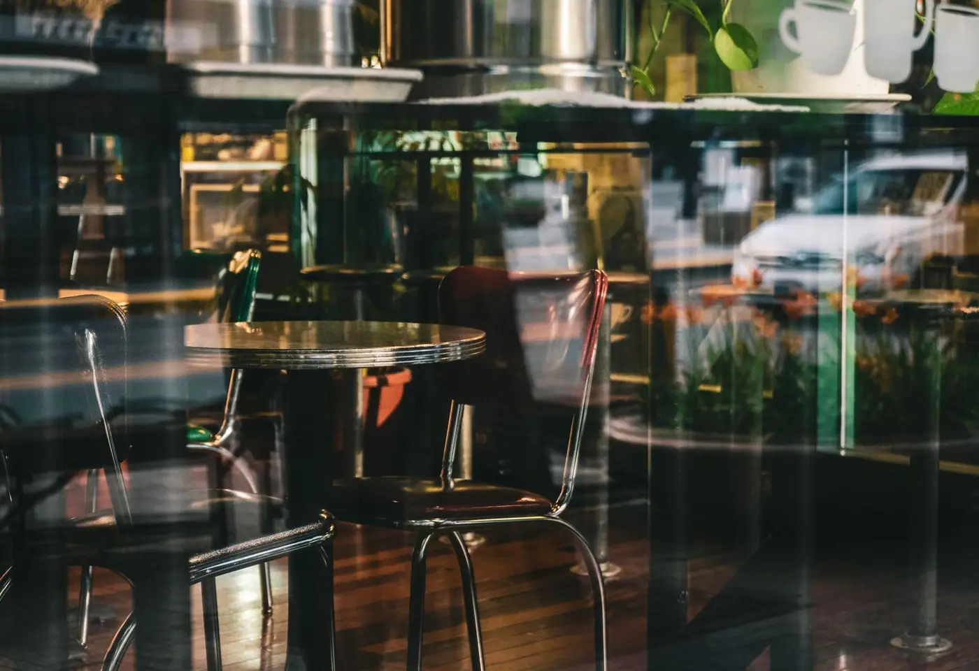 Elegant interior of a modern café with glass reflections and sleek furnishings, creating a serene ambiance.