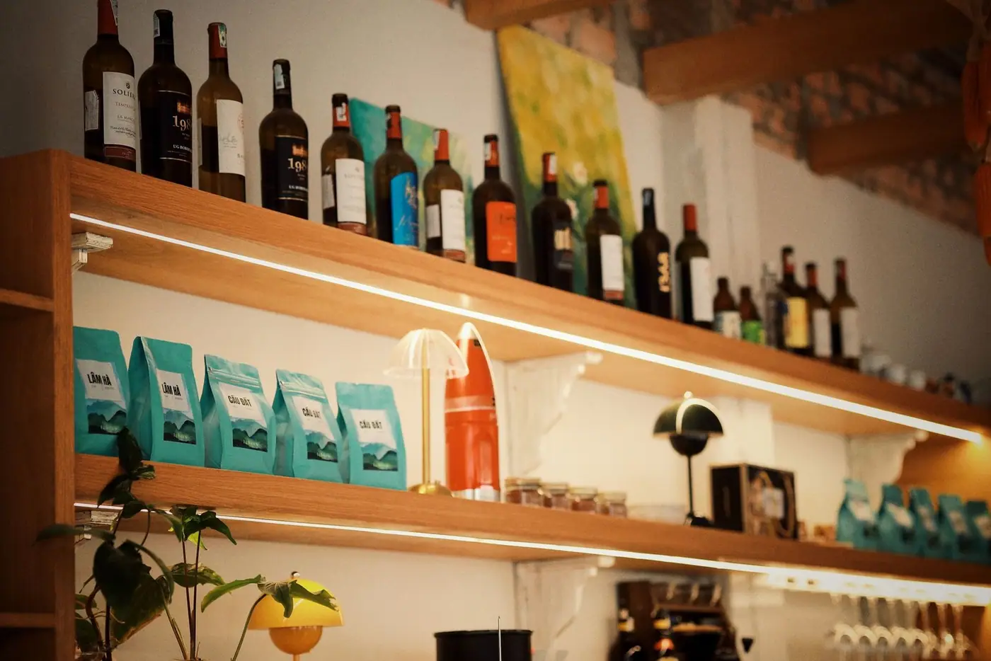 Warm and inviting cafe shelf with wine bottles and coffee bags, creating a cozy atmosphere.