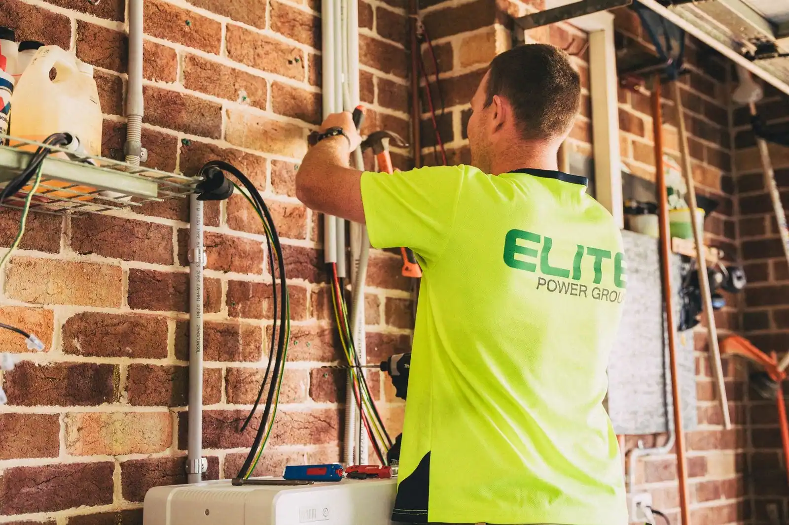 Electrician performing solar battery installation for sustainable energy storage in a home setting