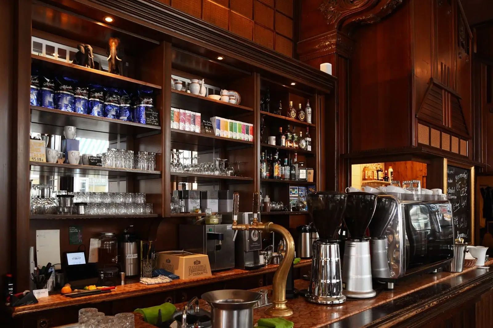 Elegant coffee shop counter displaying an espresso machine and various drinks.