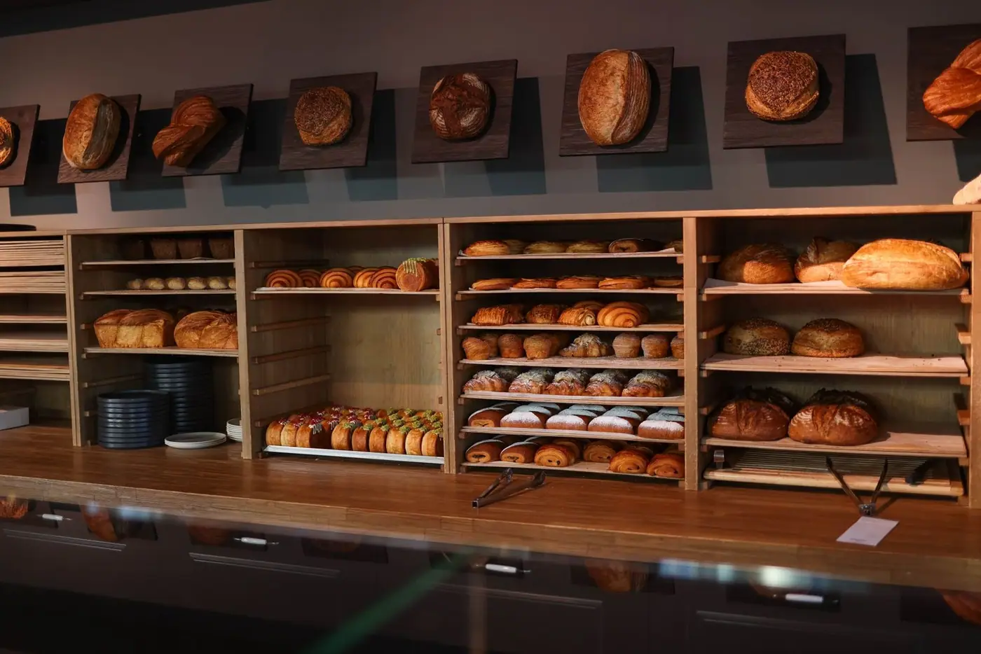 A display of freshly baked bread and pastries in a cosy artisan bakery interior