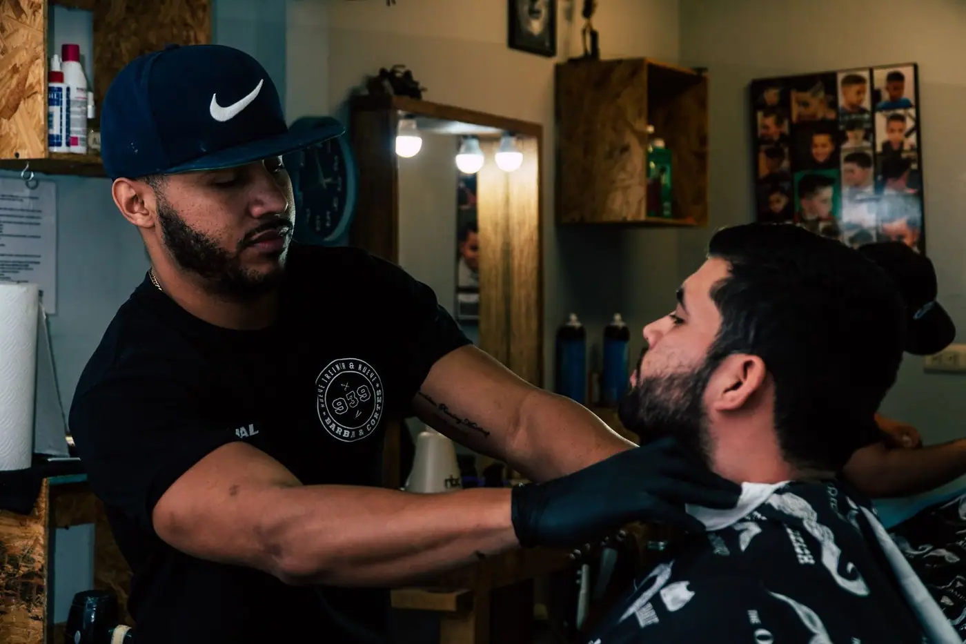 A barber trimming a man's hair in a modern barbershop