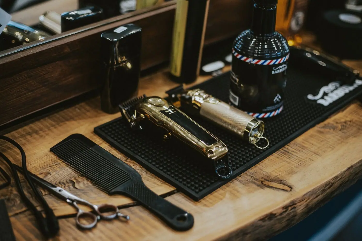 Close-up of barber tools on a wooden table including clippers and comb in a Polish barbershop.