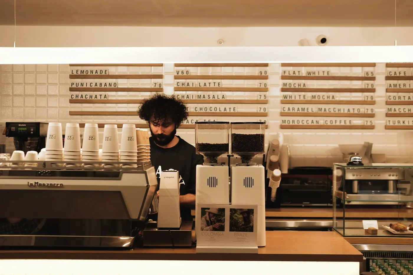 A barista making coffee using a professional espresso machine in a modern café.