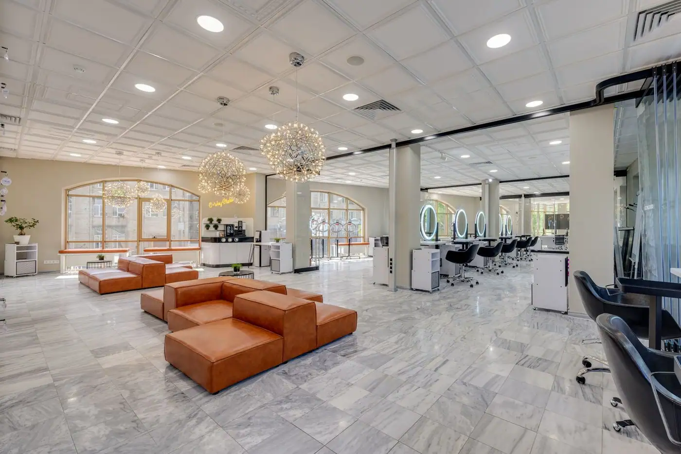 Elegant and cozy modern salon with ample natural light and stylish decor.