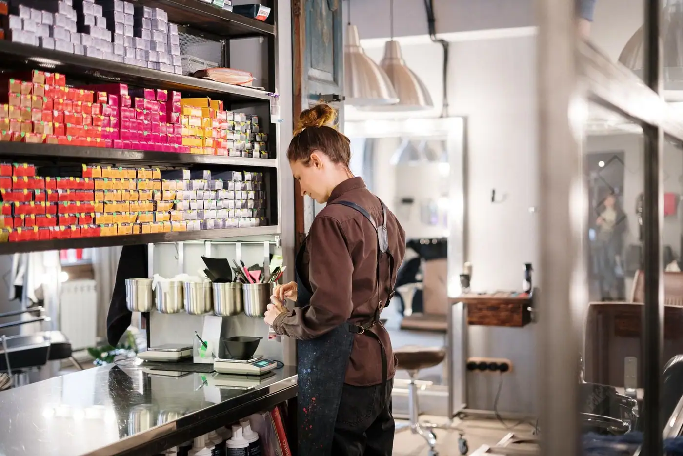 Hairdresser organizing hair color products in a modern salon.