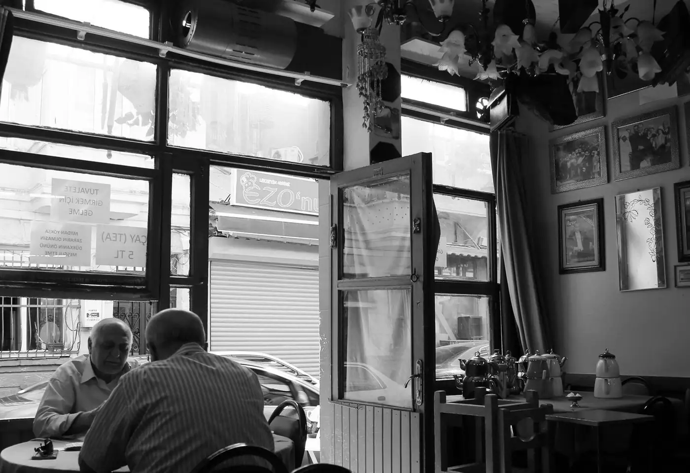 A serene black and white image of elderly men dining in a cozy café.