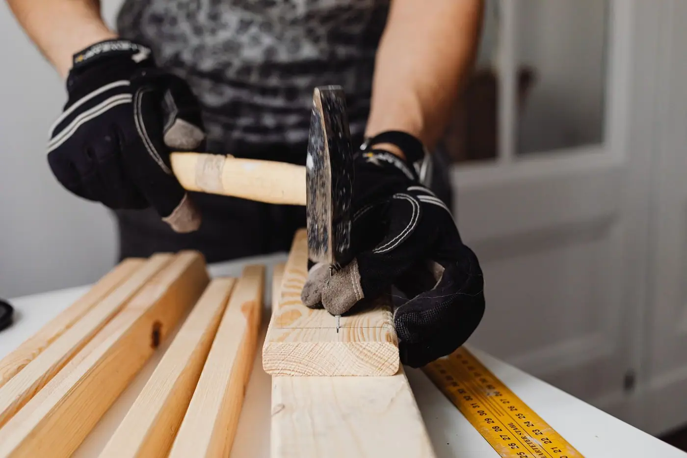 Craftsman hammering nails into wood, with woodworking tools in action