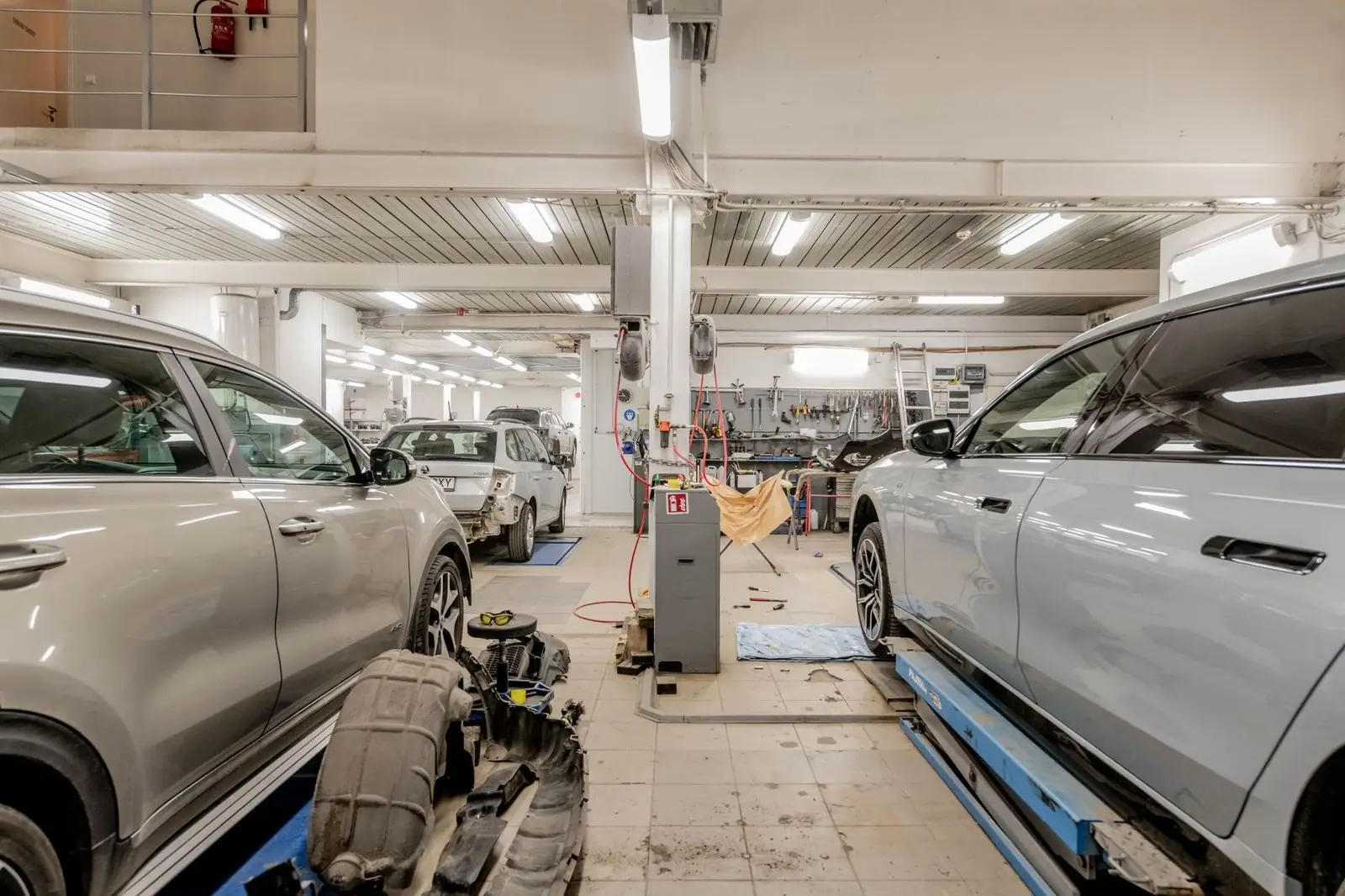 Interior of an automotive repair shop with cars undergoing maintenance and servicing