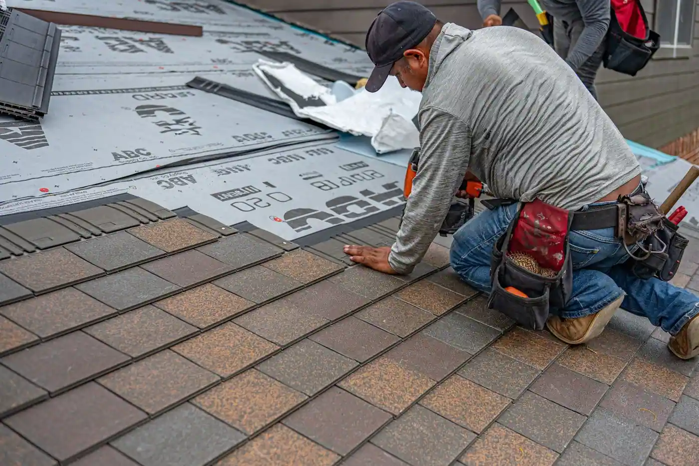Roofer installing asphalt shingles
