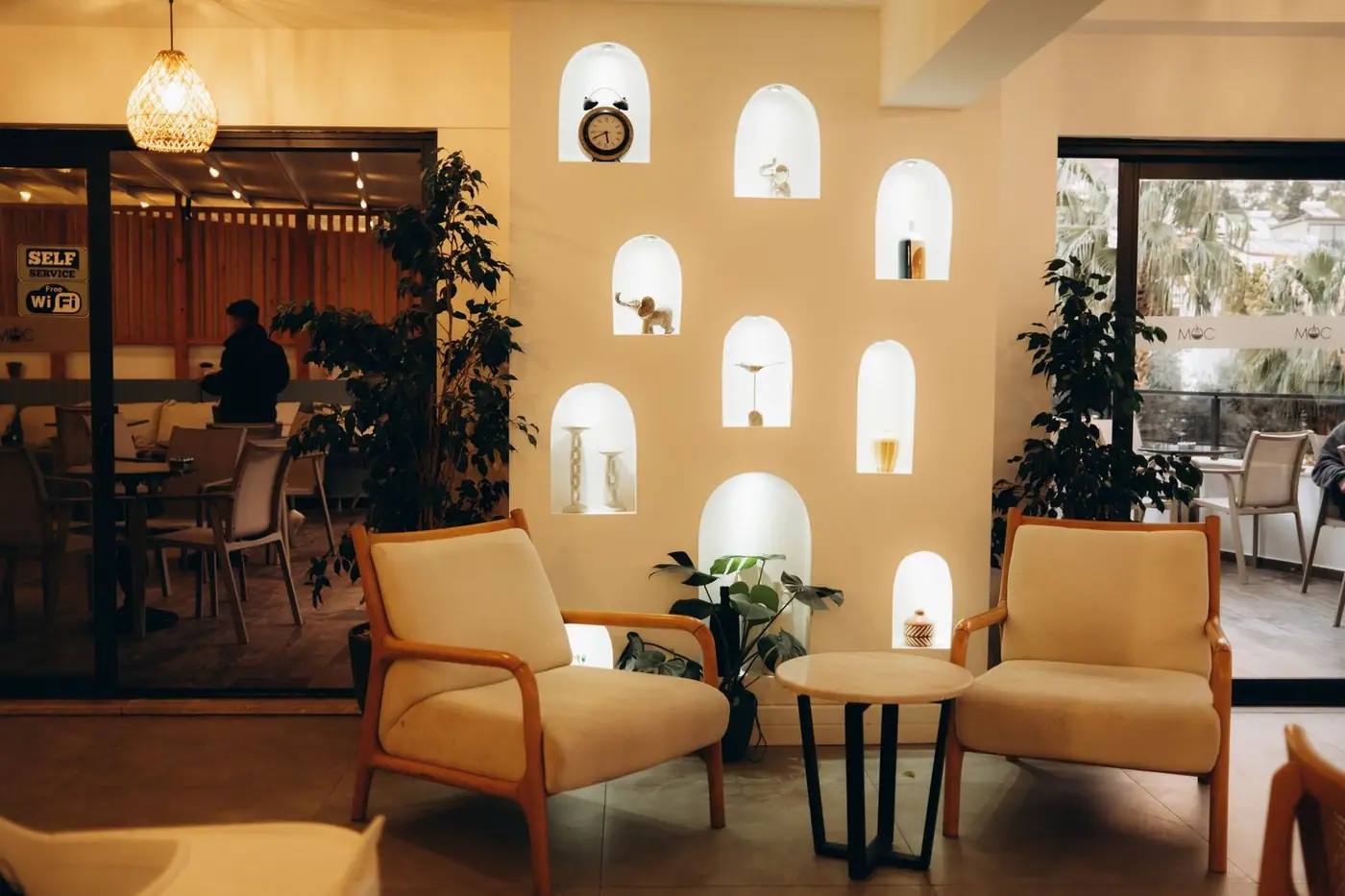 A stylish indoor cafe with modern decor, comfortable seating and illuminated niches