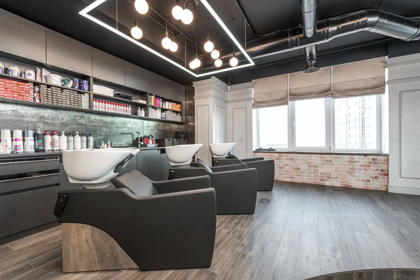 Modern backwash chairs with white sinks near shelves of grooming products