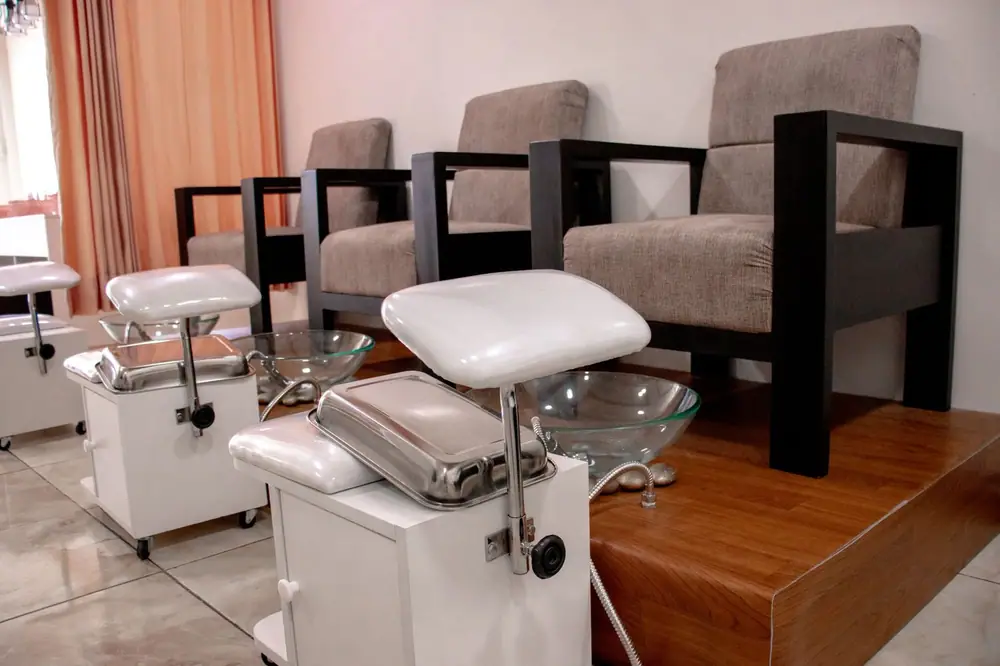 A stylish pedicure salon setup featuring comfortable armchairs and pedicure chairs with basins.